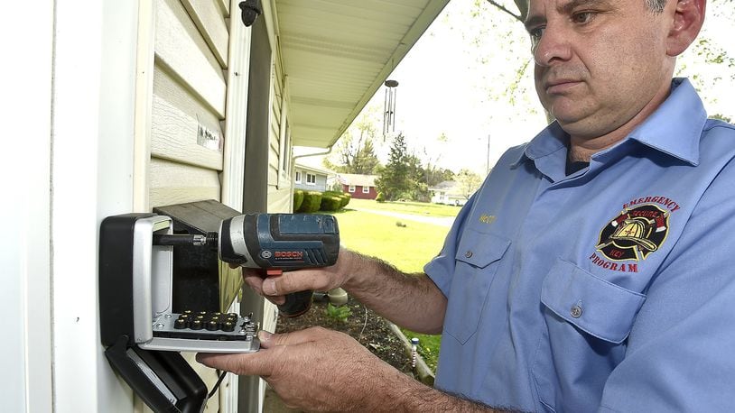 Vince McCoy, one of the owners of Secure-a-Key, installs a key box on the front of a house in Springfield. McCoy and his partner Rob Fenwick started a company where keys lockboxes are placed on elderly people’s homes in the event where medics are called to the house and can’t get in during an emergency. Bill Lackey/Staff