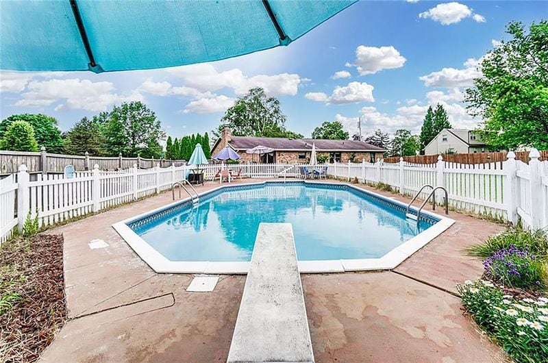 The family room sliding glass doors lead to a concrete patio that has been extended with brick pavers. This area leads to a fenced, in-ground pool with two pool ladders, a diving board and painted concrete around the pool. CONTRIBUTED PHOTO