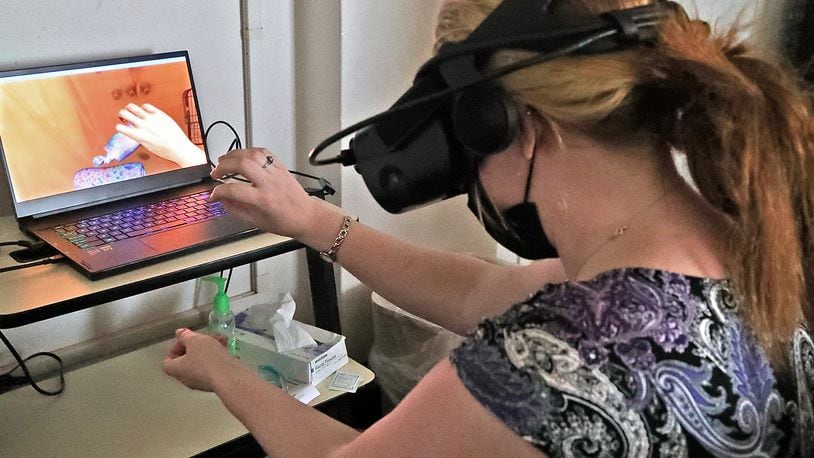 A subject wears wears a virtual reality headset as she participates in the Embodied Labs program at the Springfield Masonic Community Friday, July 1, 2022. The device puts nurses and other caregivers in the position of someone with cognitive or physical problems. BILL LACKEY/STAFF