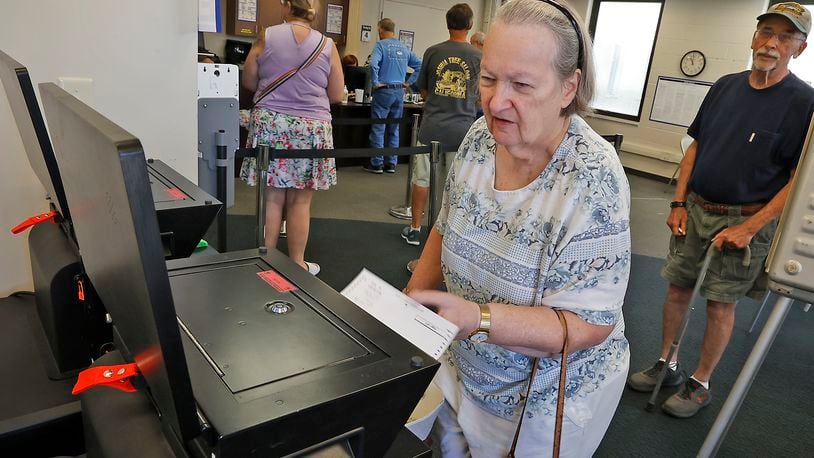 Dolores Simons slides her ballot in the voting machine as she votes early at the Clark County Board of Elections Friday, August 4, 2023. BILL LACKEY/STAFF