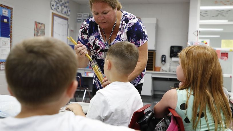 Horace Mann Elementary School teacher Kim Briggs collects school supplies from her first grade students Wednesday during the first day of school. Bill Lackey/Staff