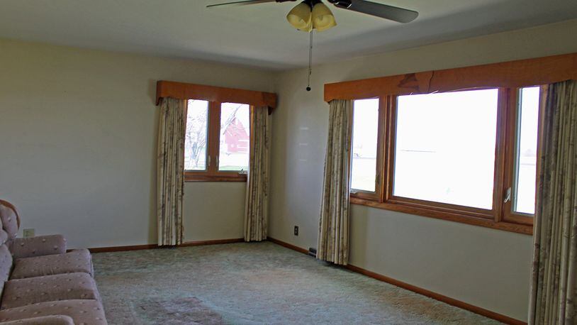 Two large windows in the living room provide views of the front and side yards.