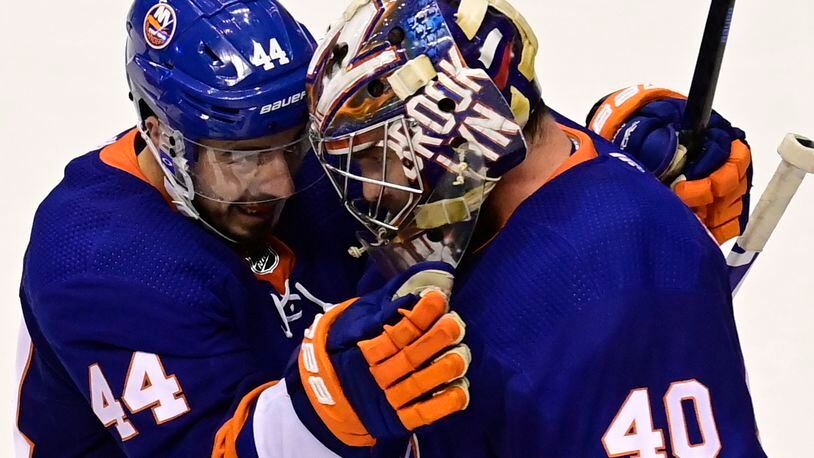 New York Islanders center Jean-Gabriel Pageau (44) celebrates with goaltender Semyon Varlamov (40) after defeating the Philadelphia Flyers in NHL Stanley Cup Eastern Conference playoff hockey game action in Toronto, Saturday, Aug. 29, 2020. (Frank Gunn/The Canadian Press via AP)