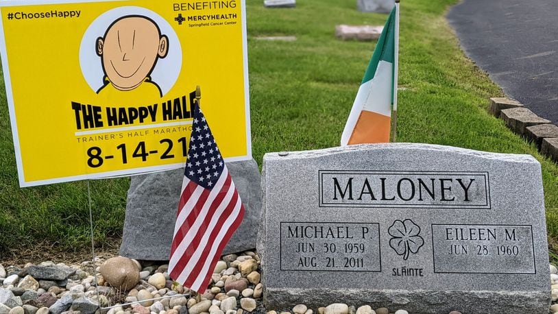 A Happy Half Marathon sign stands in Saint Bernard Cemetery next to the grave of Mike Maloney, whose battle with cancer inspired the race in Springfield. Photo by Eileen Maloney