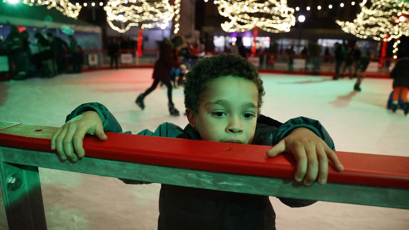 Noah Campbell works his way along the wall of the outdoor ice skating rink on the Springfield City Hall Plaza as he tries ice skatting for the first time Friday, Nov. 25, 2022. BILL LACKEY