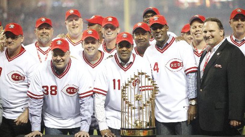 Former Reds, including Barry Larkin (11) and Eric Davis (44), pose with the World Series trophy during a 25th anniversary celebration of the 1990 World Series championship on Friday, April 24, 2015, at Great American Ball Park in Cincinnati. David Jablonski/Staff