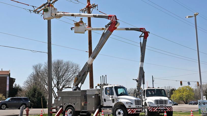 An Ohio Edison crew works on the power lines at the intersection of Urbana Road and Moorefield Road Wednesday, April 19, 2023. BILL LACKEY/STAFF