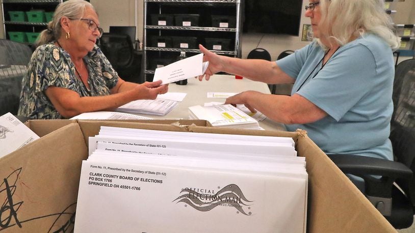 Cheryl Berry, left, and Cindy Reeder stuff absentee ballots into envelopes at the Clark County Board of Elections Monday, July 18, 2022. BILL LACKEY/STAFF