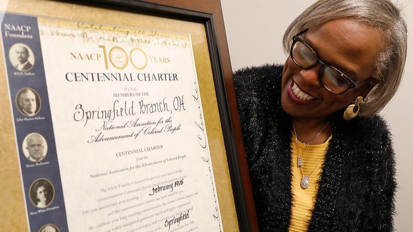 Denise Williams, president of the Springfield NAACP, looks over the centennial certificate recognizing the 100 years of the Springfield Unit’s existence. Bill Lackey/Staff