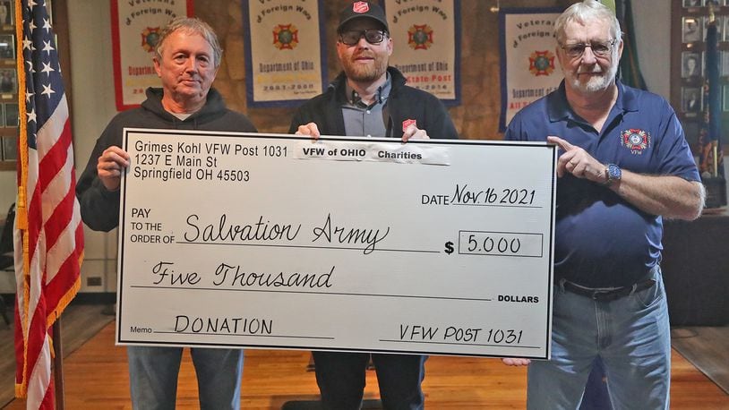 Members from the VFW Post 1031, Rick Boop, post commander, left, and Bobby Crabtree, senior vice commander, right, presented Ryan Ray, from the Springfield Salvation Army with a $5,000 check Thursday. The Salvation Army was just one of the local charities the VFW helped this week that totalled $25,000. BILL LACKEY/STAFF