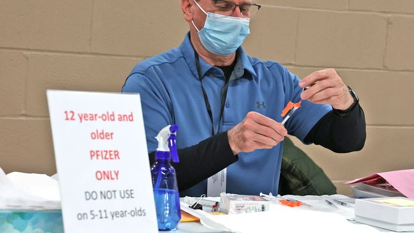 Doug Wyandt gets a COVID vaccine ready at the Clark County Combined Health District's vaccination center earlier this month. BILL LACKEY/STAFF