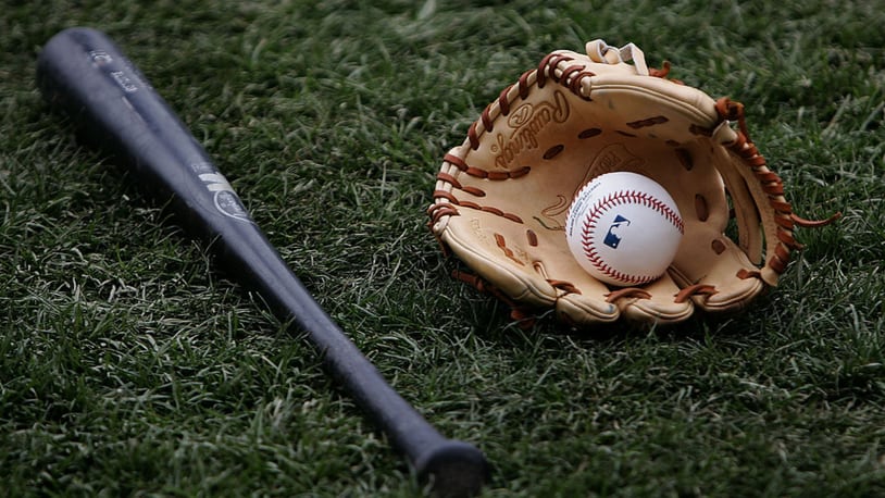 FILE PHOTO: A bat, glove and ball rest on the field.