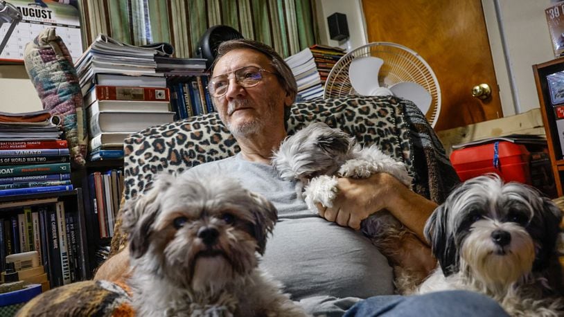 Joseph F. Applegate sits in his favorite chair, in his favorite room with his Shih tzus in his north Dayton home.  Applegate made the mortgage payments every month, but his deceased partner's name was on the deed, which has caused a dispute with Medicaid. JIM NOELKER/STAFF