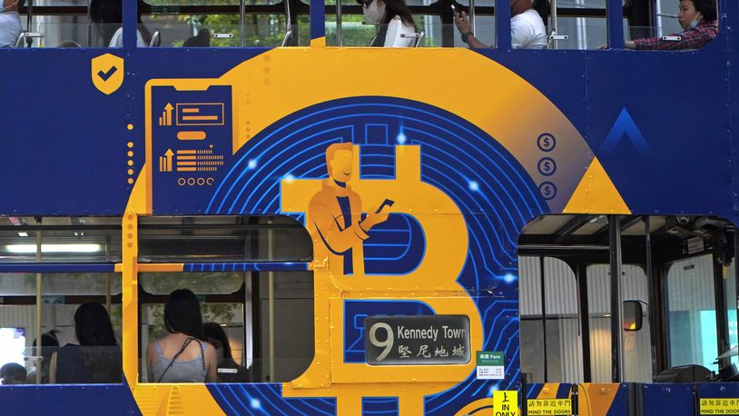 FILE - An advertisement for the cryptocurrency Bitcoin displayed on a tram, May 12, 2021, in Hong Kong. Sometime in the next few days or even hours, the “miners” who chisel bitcoins out of complex mathematics are going to take a 50% pay cut — effectively slicing new emissions of the world’s largest cryptocurrency in an event called bitcoin halving. (AP Photo/Kin Cheung, File)