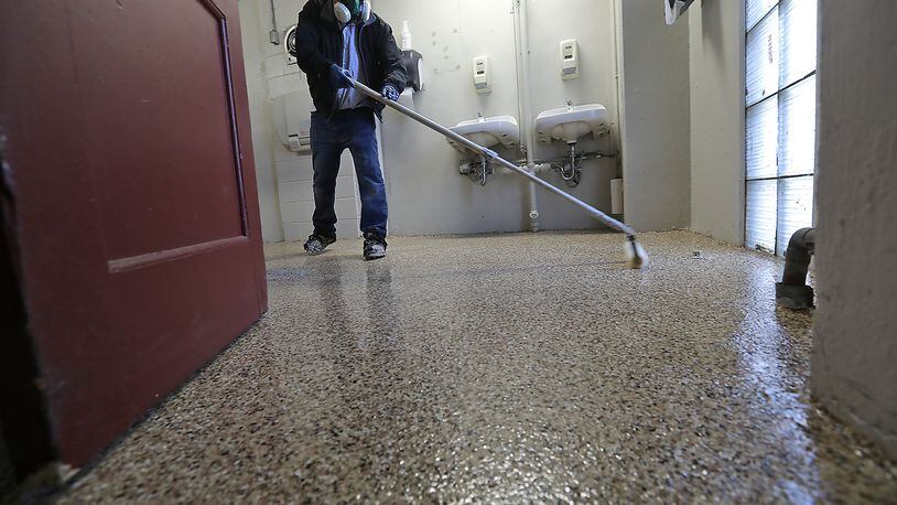 A worker puts down a new FLEXMAR Polyaspartic floor coating in one of the updated restrooms at the Clark County Fairgrounds. BILL LACKEY/STAFF