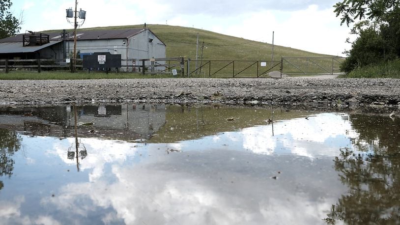 The Tremont City Barrel Fill is reflected in a puddle. There is a current effort to cleanup some of the toxic chemical waste located at the site. Bill Lackey/Staff