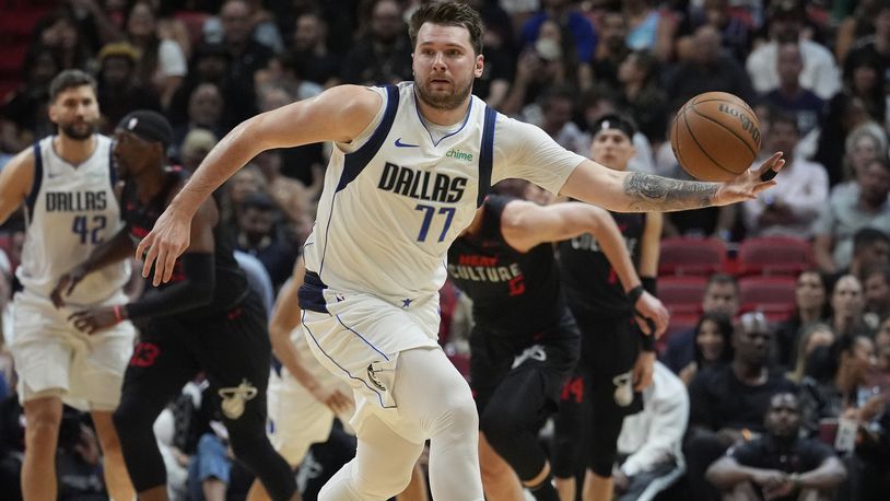 Dallas Mavericks guard Luka Doncic (77) grabs a loose ball during the first half of an NBA basketball game against the Miami Heat, Wednesday, April 10, 2024, in Miami. (AP Photo/Marta Lavandier)