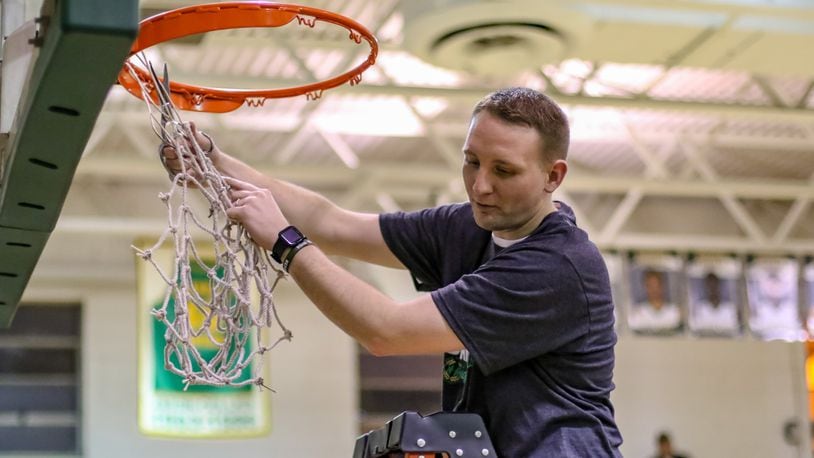 Catholic Central High School basketball coach Cody Sarensen cuts down the net after the Irish beat Cedarville on Feb. 5 to clinch their second straight Ohio Heritage Conference South Division title. Sarensen recently resigned to join the coaching staff at Wittenberg University. CONTRIBUTED PHOTO BY MICHAEL COOPER