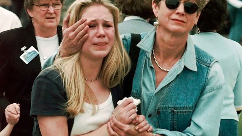 FILE - Fran Allison, right, comforts her daughter, Brooke, after they were reunited following a shooting at Columbine High School in Littleton, Colo., April 20, 1999. Twenty-five years later, The Associated Press is republishing this story about the attack, the product of reporting from more than a dozen AP journalists who conducted interviews in the hours after it happened. The article first appeared on April 22, 1999. (AP Photo/Ed Andrieski, File)