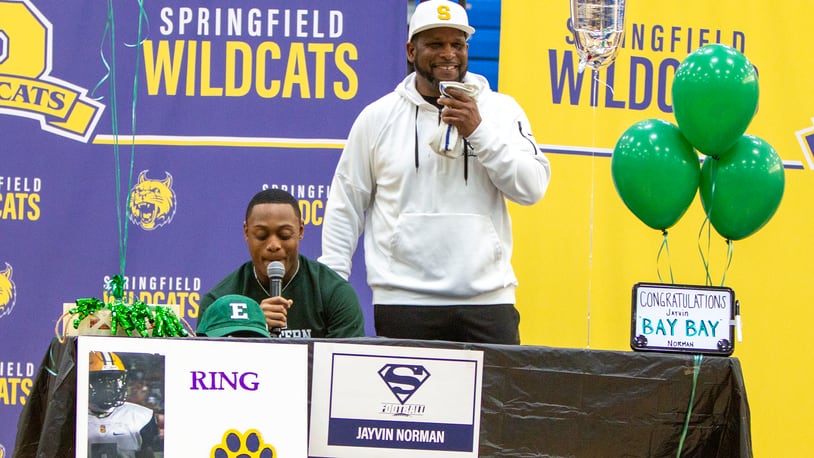 Springfield running back Jayvin "Bay Bay" Norman thanks those who helped him and announces his decision to attend Eastern Michigan while head coach Maurice Douglass laughs at Norman's remarks on Wednesday in the school gym. Jeff Gilbert/CONTRIBUTED