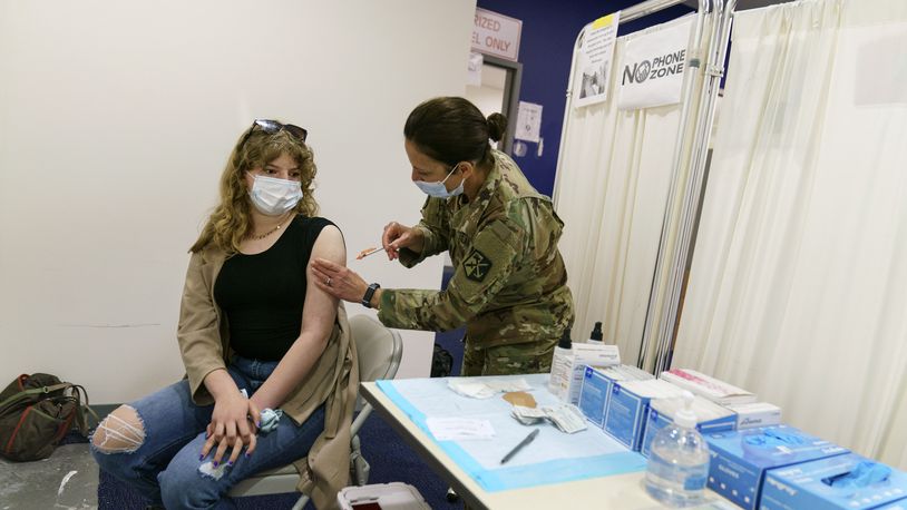 Lillian Ranney, 12, left, receives her first dose of the Pfizer COVID-19 vaccine from Rhode Island Air Force National Guard Lt. Col. Barbara Webster at a mass vaccination site at the former Citizens Bank headquarters in Cranston, R.I., Thursday, May 13, 2021. (AP Photo/David Goldman)