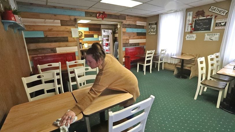Brittany Lachey cleans a table in the dinning room of the Stagecoach Cafe in New Carlisle Thursday. When it comes to small businesses in Clark County, it doesn't come much smaller than the Stagecoach with a seating capacity less than 20 people. BILL LACKEY/STAFF