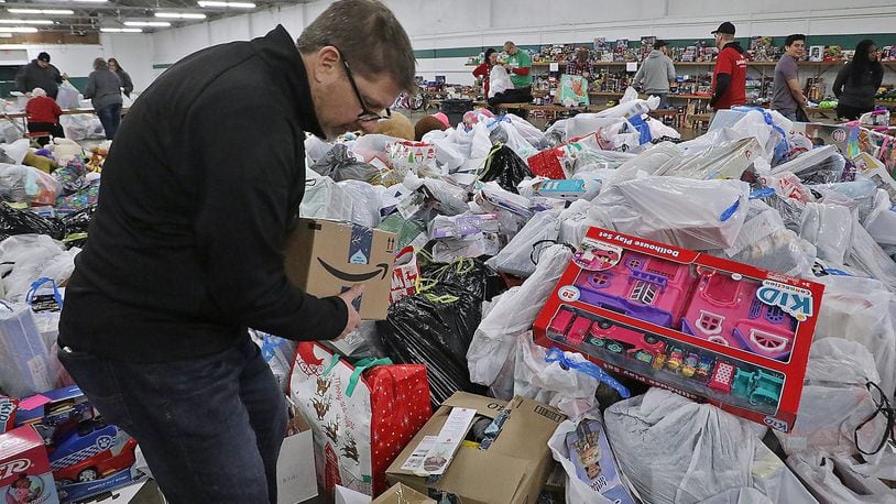 Kevin Kolenda, from Gordon Foods, sorts through the giant pile of toys dropped off by Speedway employees Friday at the Salvation Army’s “Toy Shop.” Speedway is supplying Christmas gifts for over 700 needy kids in the Springfield through the Salvation Army’s Angel Tree program. BILL LACKEY/STAFF