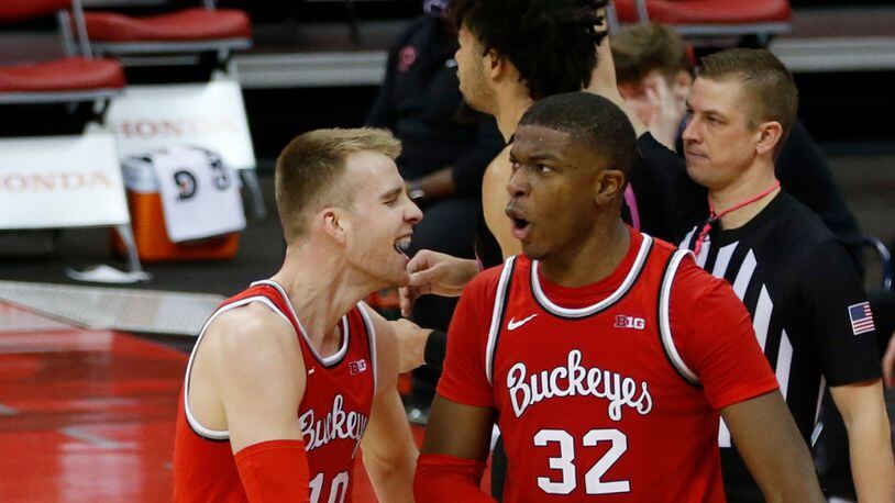 Ohio State's E.J. Liddell, right, celebrates grabbing with teammate Justin Ahrens during the second half of an NCAA college basketball game Wednesday, Jan. 27, 2021, in Columbus, Ohio. Ohio State beat Penn State 83-79. (AP Photo/Jay LaPrete)