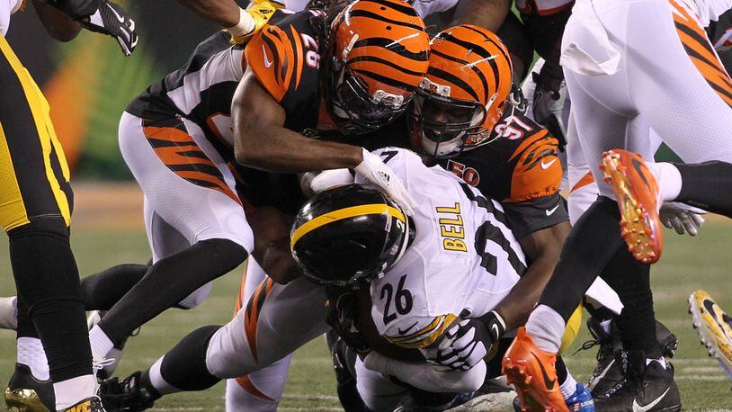 CINCINNATI, OH - DECEMBER 04: Geno Atkins #97 and Josh Shaw #26 of the Cincinnati Bengals tackle Le’Veon Bell #26 of the Pittsburgh Steelers during the first half at Paul Brown Stadium on December 4, 2017 in Cincinnati, Ohio. (Photo by John Grieshop/Getty Images)