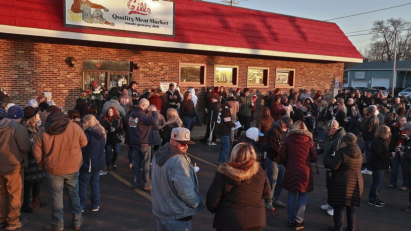 Family, friends and community members fill the parking lot of Gill's Quality Meat Market Monday, Jan. 9, 2023 during a candle light vigil for Thomas Gill, who was shot and killed Jan. 5 while driving his SUV in Springfield. BILL LACKEY/STAFF
