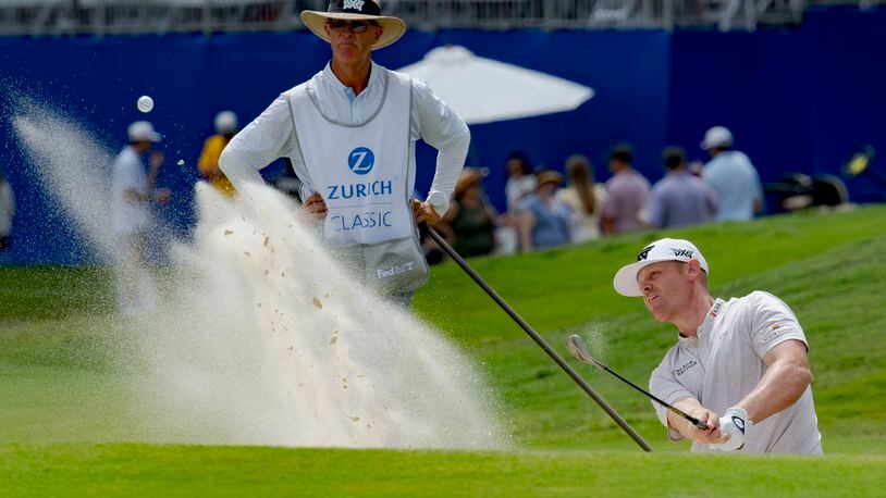 Patrick Fishburn, right, hits from a bunker on the 18th hole during the third round of the PGA Zurich Classic golf tournament at TPC Louisiana in Avondale, La., Saturday, April 27, 2024. (AP Photo/Matthew Hinton)