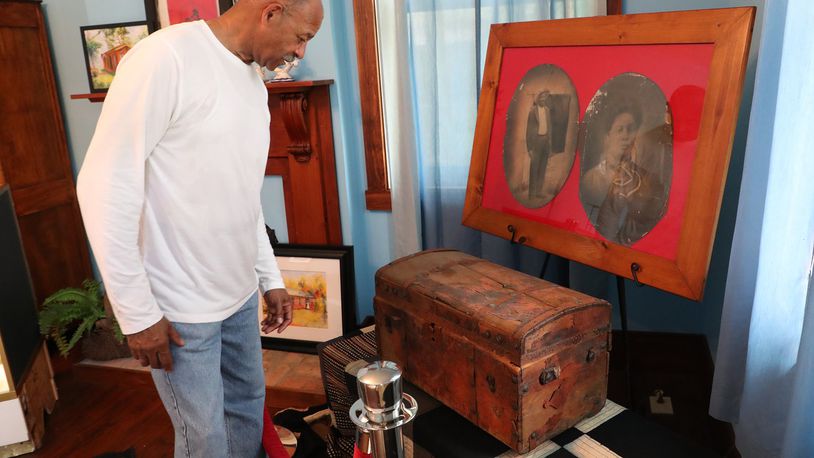Dale Henry, president of Gammon House, Inc., looks over a trunk and pictures that belonged to Addison White, a runaway slave who’s freedom was purchased by the residents of Mechanicburg in 1857, on display in the Gammon House for the Juneteenth and Fatherfest Celebrations a few years ago. Bill Lackey/Staff