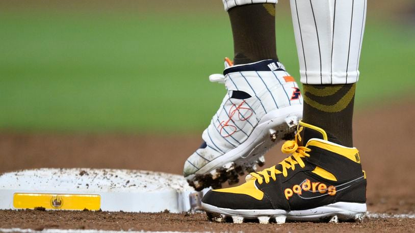 FILE - San Diego Padres' Fernando Tatis Jr. (23) wears cleats commemorating the Padres's 1980's and 1990's teams during a baseball game against the Chicago Cubs, Monday, April 8, 2024, in San Diego. Tatis plans to unveil 50 pairs of custom cleats this season in conjunction with his branding company, Xample, and Los Angeles-based Shoe Surgeon. The cleats will honor people, events and whatever strikes the 25-year-old Tatis' fancy. (AP Photo/Denis Poroy, File)