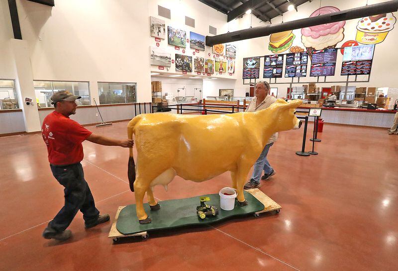 Workers roll a decorative cow through the new Young's Jersey Dairy Tuesday on its way to be hung above the entrance. The new dairy will have a soft opening on Thursday and a grand opening at a later date. BILL LACKEY/STAFF