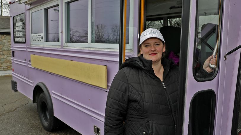 Mandy Gabbert, from Path Integrated Healthcare, in the purple bus they serve free dinners out of for homeless and hungry people. BILL LACKEY/STAFF