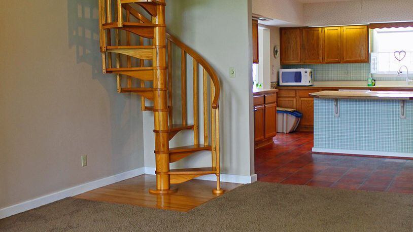 Features of the living room include an open spiral staircase that leads to the second floor.