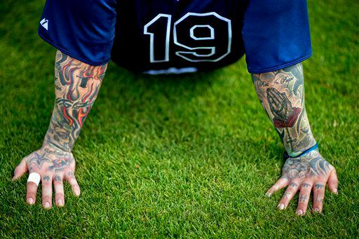 Tattoos decorate the arms of Tampa Bay Rays' Ryan Roberts as he takes a rest during a spring training baseball workout.