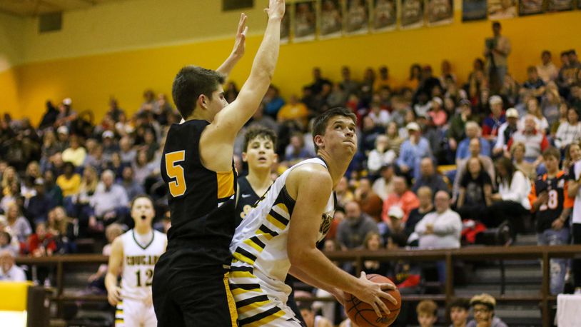 Kenton Ridge senior Collin Perkins makes a move to the basket while being guarded by Shawnee’s Isaac Siemon during their game on Friday night in Springfield. The Cougars won 48-45. CONTRIBUTED PHOTO BY MICHAEL COOPER