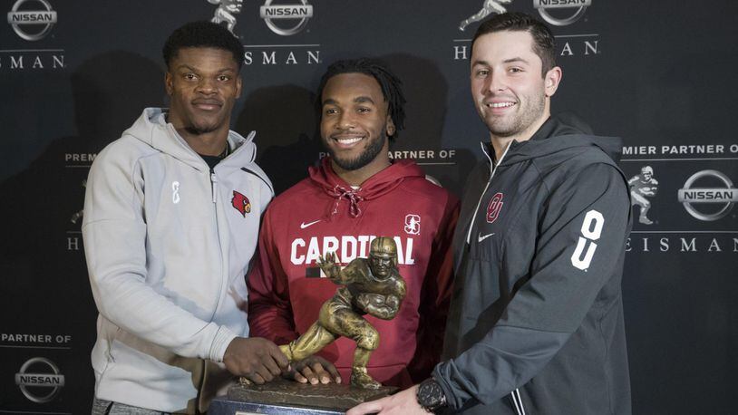 Heisman Trophy finalists, from left, Louisville quarterback Lamar Jackson, Stanford running back Bryce Love and Oklahoma quarterback Baker Mayfield pose with the award during a media event Friday in New York. (AP Photo/Mary Altaffer)