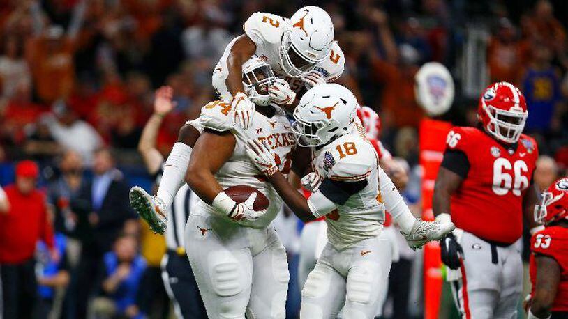 Texas defensive lineman Gerald Wilbon (94) celebrates his fumble recovery with defensive backs Kris Boyd (2) and Davante Davis (18) during the first half of the Sugar Bowl in New Orleans, Tuesday, Jan. 1, 2019.