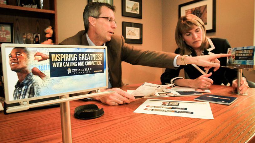 Cedarville University’s Mark Weinstein and Janice Supplee look over new campaign materials called “Calling and Conviction” that will be on billboards and other marketing materials. Colleges are spending big money to lure students in a competitive environment with a shrinking pool of students. Cedarville, a Christian college with about 3,400 students, will invest about $400K in a national ad campaign this year - money they say they have to spend so students will consider the school.