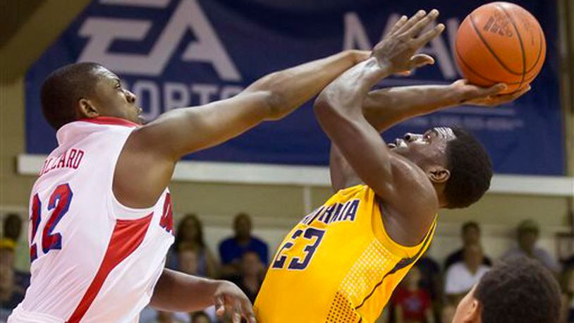 Dayton forward Kendall Pollard, left, attempts to block a shot by California guard Jabari Bird (23) in the second half of an NCAA college basketball game at the Maui Invitational on Wednesday, Nov. 27, 2013, in Lahaina, Hawaii. Dayton won 82-64. (AP Photo/Eugene Tanner)