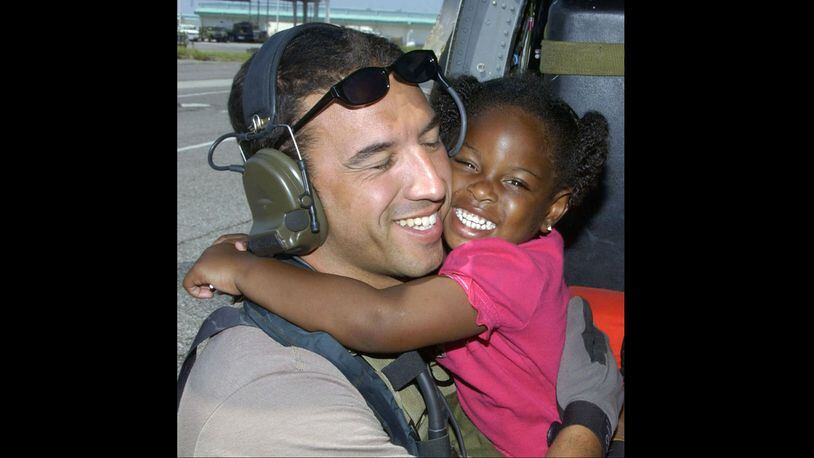 Lashay Brown, 3, hugs Air Force Staff Sgt. Mike Maroney, as she is relocated to the New Orleans International Airport on Sept. 7, 2005, after Hurricane Katrina flooded her family's home.