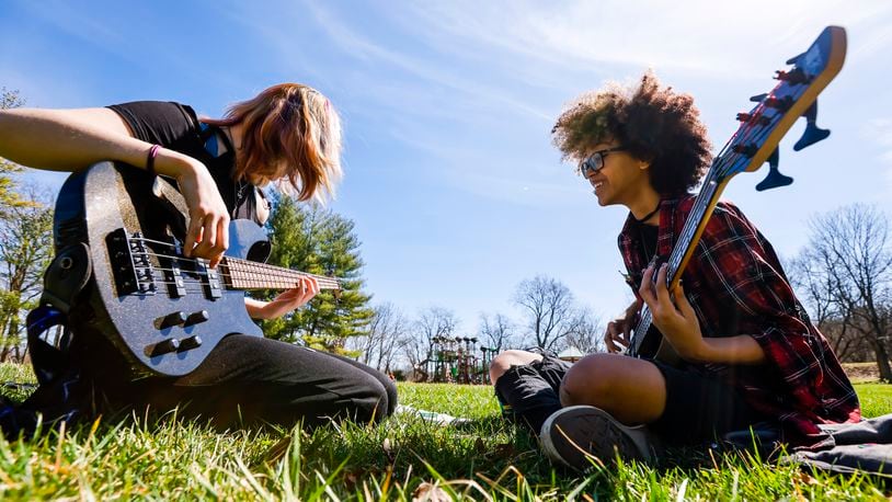 Justice Poole, right, teaches Heather Hatfield how to play a song on bass guitar on a sunny day at Rentschler Forest Metropark Monday, March 21, 2022 in Hamilton. NICK GRAHAM/STAFF