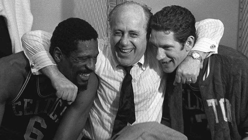 Boston Celtics general manager Red Auerbach, center, hugs Celtics stars Bill Russell, left, and John Havlicek after defeating the Los Angeles Lakers to win the NBA Championship, in Los Angeles, in this May 3, 1968 photo. (AP Photo/File)