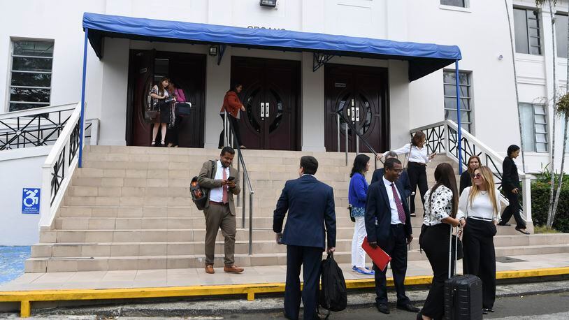 Lawyers and court workers leave the Supreme Court during a recess for the trial of the "Panama Papers" money laundering case in Panama City, Monday, April 8, 2024. (AP Photo/Agustin Herrera)