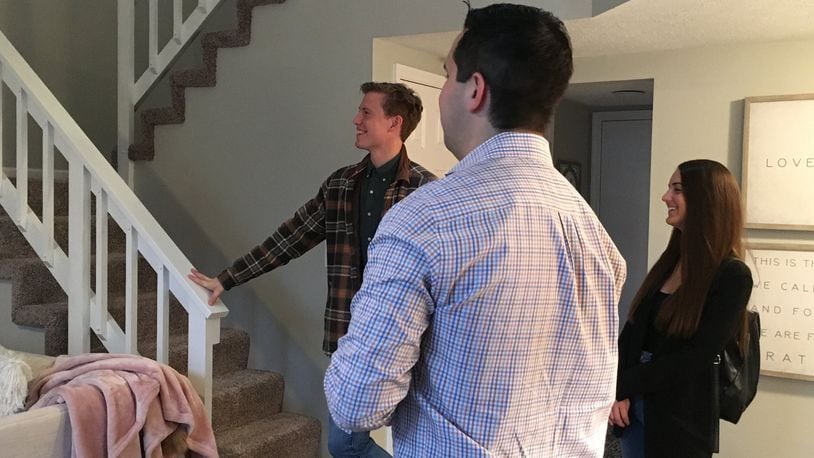 Engaged couple Ryan Runyeon and Malloree Hagerty, both millennials, are looking to buy a home. Realtor Austin Castro shows the pair some options in Centerville. STAFF PHOTO / HOLLY SHIVELY