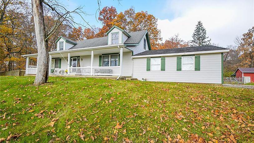 The Cape Cod-style home with 3 bedrooms and a finished, walk-out basement is set on more than 32 mostly wooded acres. The home has a full, covered front porch with railings and a concrete walk that leads to the 2-car, attached garage. CONTRIBUTED PHOTO
