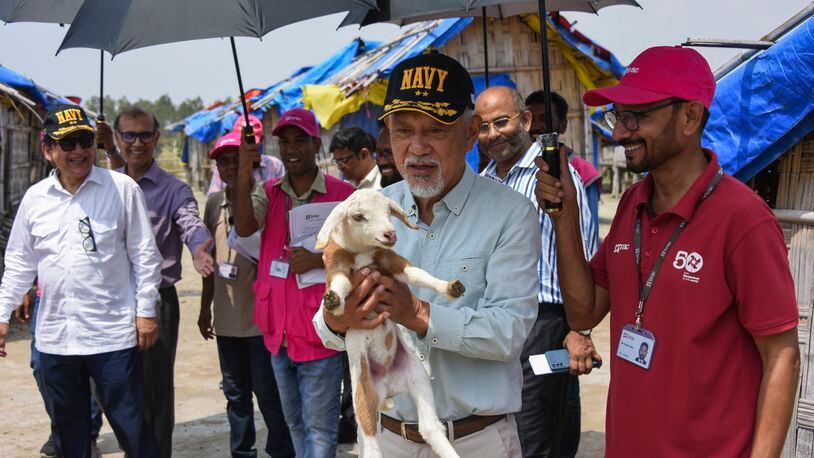 Japanese philanthropic group Nippon Foundation's Chairman Sasakawa Yohei, carries a lamb during a visit to Bhasan Char island in the Bay of Bengal, where thousands of Rohingya refugees are living in Bangladesh, Saturday, April 6, 2024. Japan's Nippon Foundation will spend $2 million to help move tens of thousands more Rohingya refugees to a remote island in Bangladesh and provide them with skills training, Sasakawa said. (Nippon Foundation via AP)