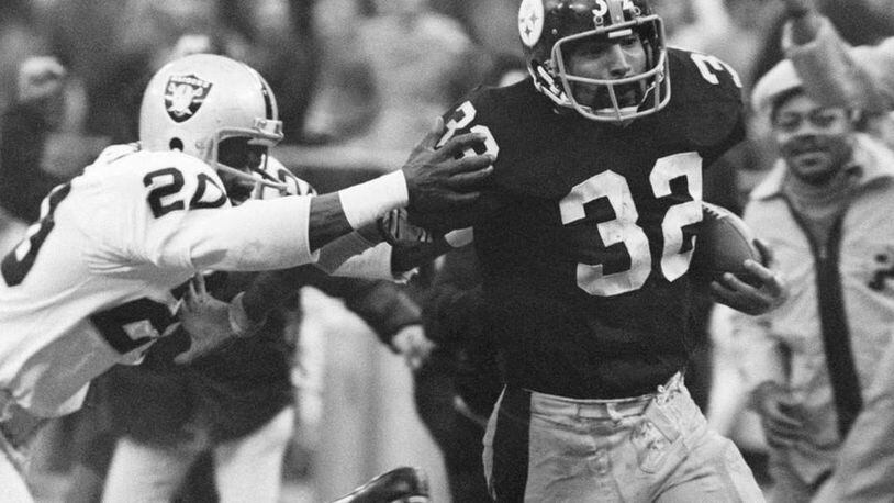 Pittsburgh Steelers' running back Franco Harris (32) eludes a tackle by Oakland Raiders' Jimmy Warren as he runs for a touchdown to complete the "Immaculate Reception." The play was voted the NFL's greatest moment Sunday. (Harry Carbluck/Associated Press)